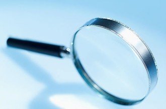 Close-up of a magnifying glass on a light surface.